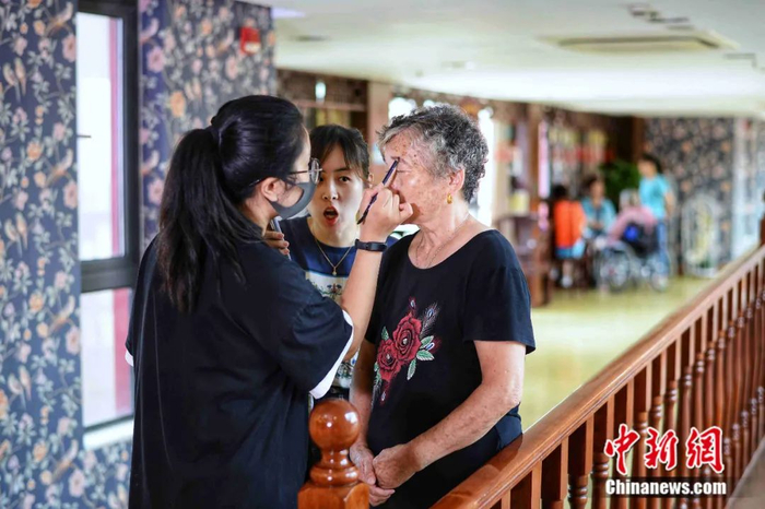 工作人员正在为奶奶化妆。上海杨浦区福利院供图