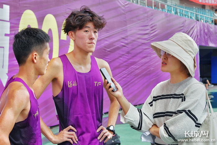 　　夺冠后接受记者采访的王梓翔（左二）。长城网记者 段美嘉 摄