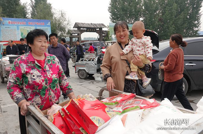东街村民领取村里发放的福利，米面油、月饼、猪肉、三黄鸡装了满满一三轮车。长城网记者 吴新光 摄