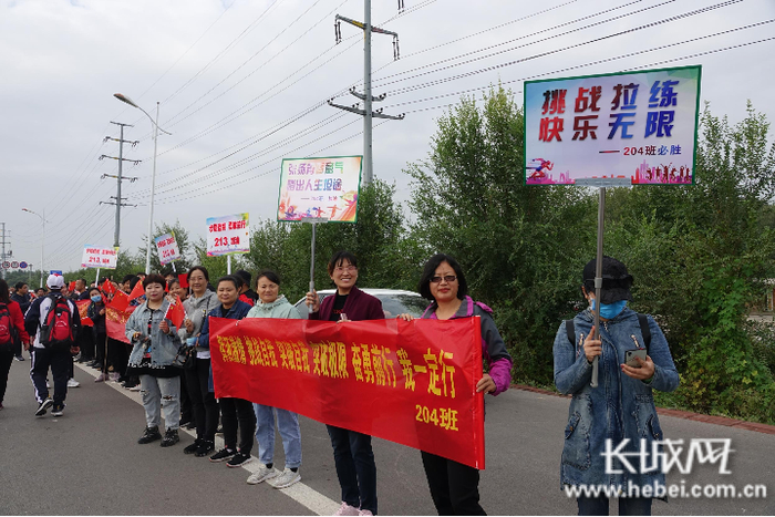 远足途中，家长们举起条幅为孩子们加油打气。长城网记者 胡竞文 摄