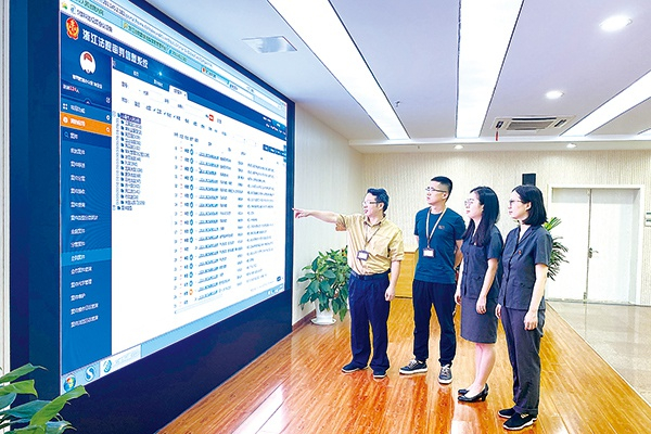 浙江省永康市纪委监委驻市人民法院纪检监察组干部与法院工作人员通过法院审判信息系统，查看比对公职人员借贷诉讼情况。摄影/胡思瑶（永康市纪委监委干部）