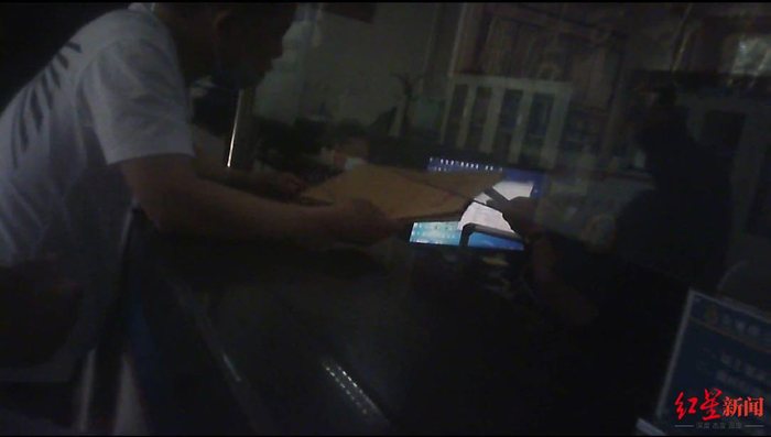 ▲与刘某某同样遭遇的邢某某等司机将装有2000元现金的档案袋递给违章处理窗口工作人员