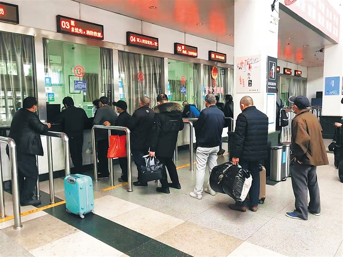 近日，海口火车站，多名老年人在人工售票窗口前排队买票。海南日报记者 郭萃 摄