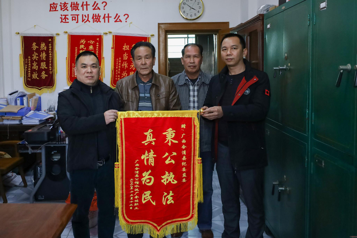 合浦县公馆镇水泥厂职工代表向纪检监察干部赠送锦旗