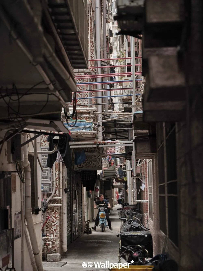 ⚪️穿梭在握手楼间的居民，灰粉色的马赛克瓷砖是这里最常见的建筑物立面。