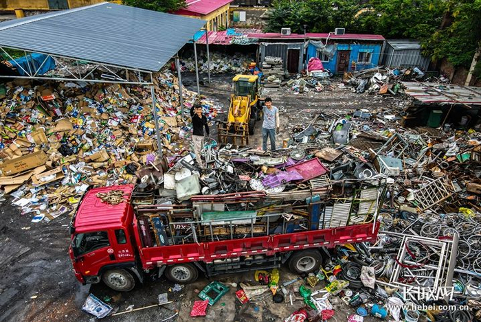 刘阿楠（左）与三弟刘阿胜在大挂车上整理废铁。长城网记者 马宁 摄