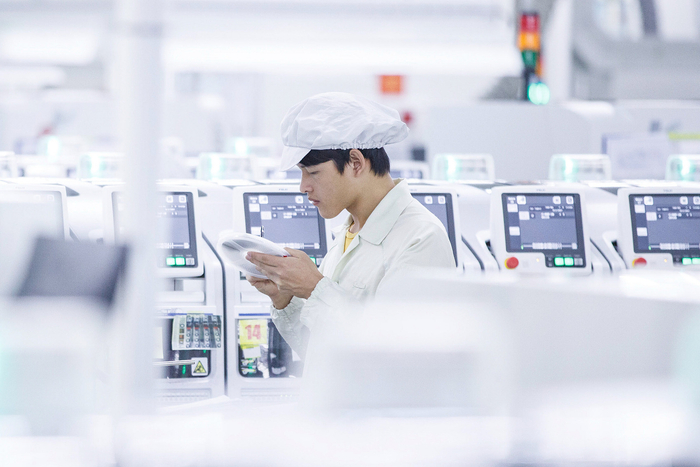 （2021年6月17日，广东东莞一自动化生产车间，技术人员正在调试智能制造设备。图源：视觉中国）