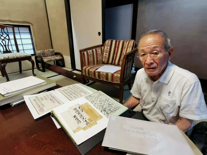 宫崎黄石向记者展示家族珍藏的史料。新华社记者 冮冶摄