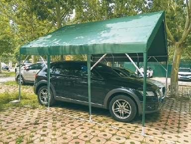 建西苑南里的停车场内，两辆车顶上搭着一个大车棚。