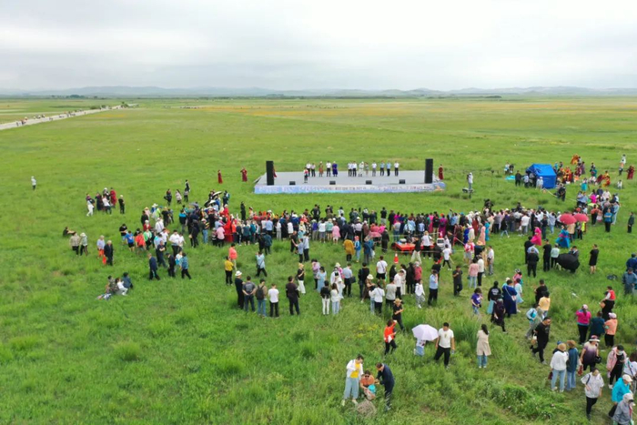 日前“2021金莲花节”开幕，游客们三三两两聚在草原上，欣赏歌舞。刘长永 摄