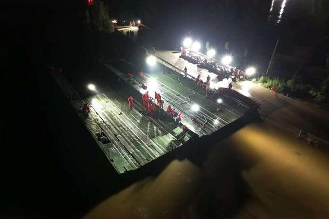救援人员深夜在河南卫辉市搭建应急动力舟桥。图片来源：中国安能