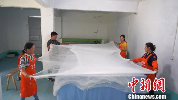 图为李先义和工人在进行丝绵加工。蒲文思 摄