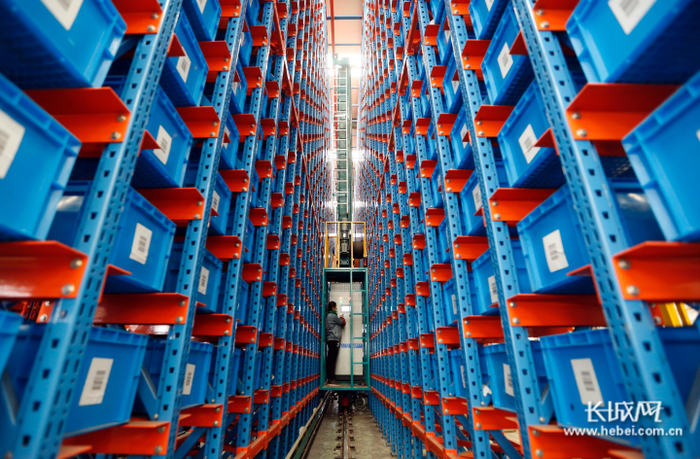 河北瑞星燃气设备公司工作人员在智能立体储存库存储半成品及零部件。