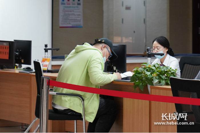 工作人员引导市民到响应窗口办理业务。长城网记者张千摄​