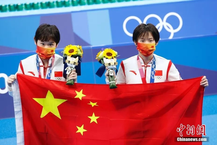 当地时间7月27日，初次亮相奥运赛场的中国跳水小将陈芋汐（右）和张家齐（左）成功夺得东京奥运会女子双人10米跳台冠军。中新社记者 韩海丹 摄
