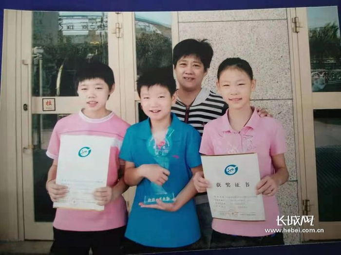 孙颖莎（蓝色衣服）与石家庄市和平西路小学乒乓球教练组组长张春欣及队友合影。吕钊/供图