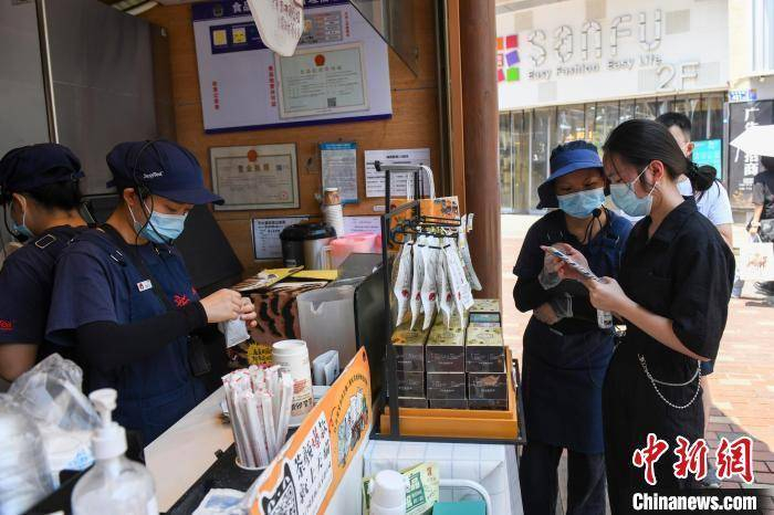 图为一“网红”奶茶店工作人员检验客人的健康码。（资料图）　杨华峰　摄