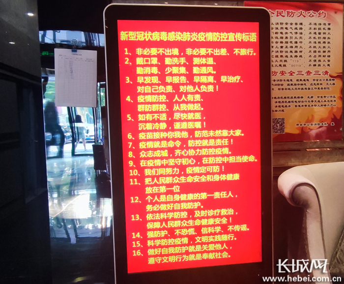 邢台市一酒店大堂内电子屏播放疫情防控宣传标语。