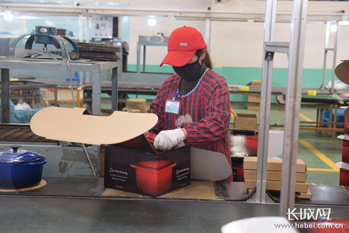 河北三厦厨具科技有限公司包装车间内，工人正将铸铁锅放到包装箱中。通讯员 潘志芳 摄