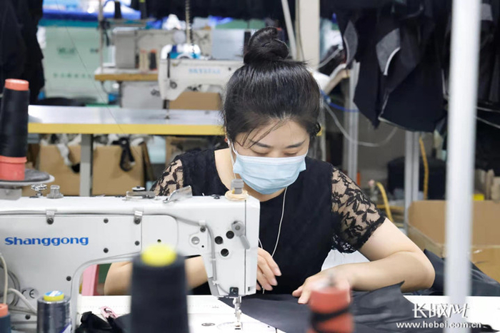 邢台市南和区郝桥镇宣宏制衣服装厂的工人正在缝制衣服。通讯员耿昭摄