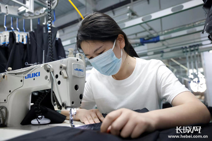 邢台市南和区郝桥镇宣宏制衣服装厂的工人正在缝制衣服。通讯员耿昭摄
