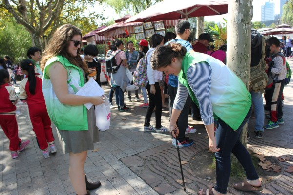 图说：外国留学生志愿者参加环境保洁