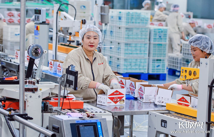 工人将流水线上的成品进行装箱作业。