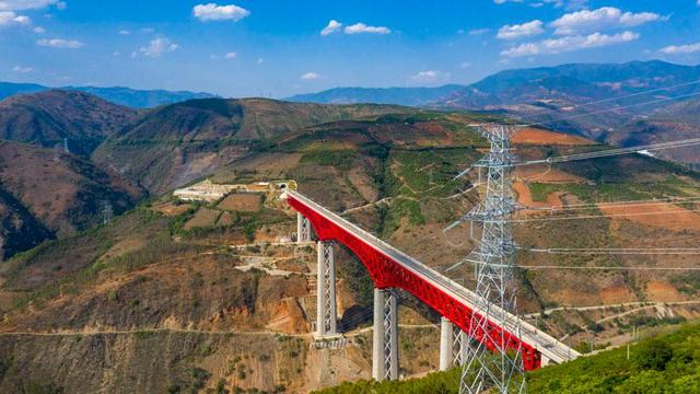 中老铁路中国段元江特大桥，供电线路为远处的220千伏南溪河牵引站提供可靠供电。贺璇、黄进雄 摄