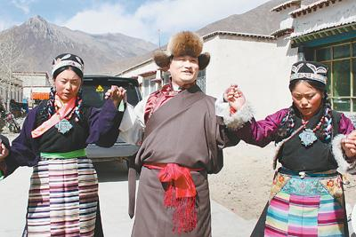 林涛（中）与当地农牧民欢度藏历新年。图源：人民日报