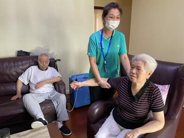 护理员李云凤（中）为杜爷爷、顾奶奶进行照护服务。 舒抒 摄