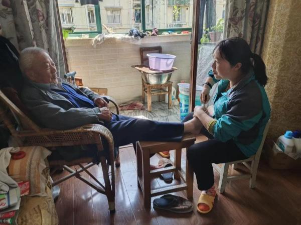 护理员在老人家中进行居家照护。 长宁区供图