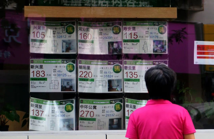  房产中介广告外驻足的路人 &nbsp;图/中国新闻图片网