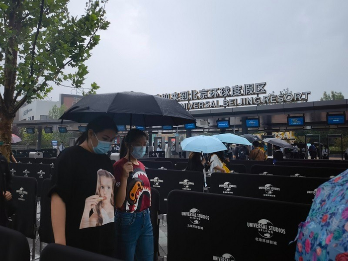 刚出地铁站，不少游客撑伞前往安检处。冉隆楠/摄