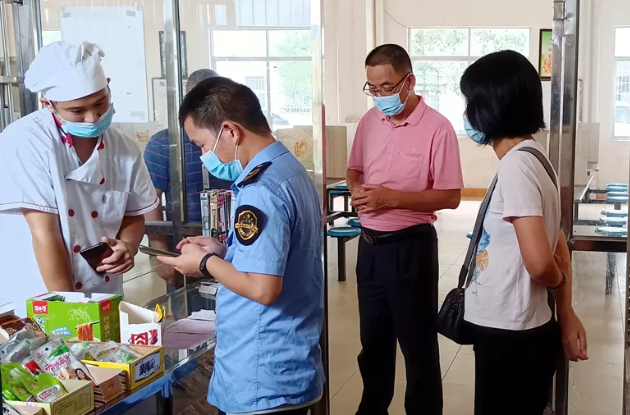 （新丰县市场监管局执法人员现场指导从业人员完成“食安快线通用版”培训考核。陈文礼 摄）