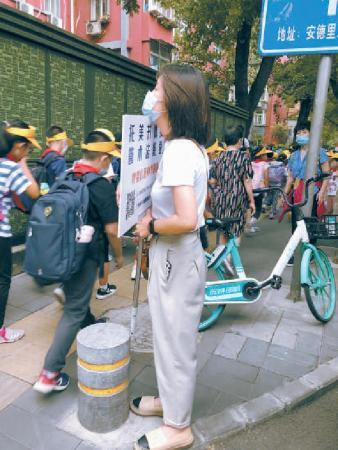 学校门口的托管机构人员等着接学生。