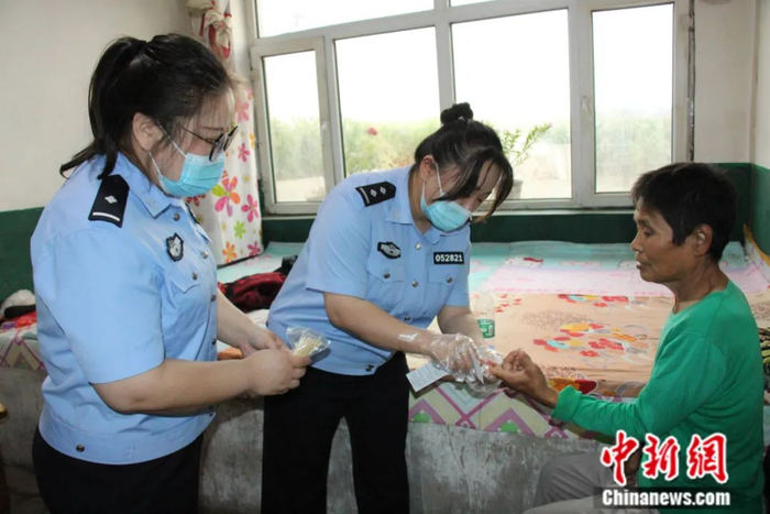 图为民警对张喜芹进行采血。张铁牛 摄