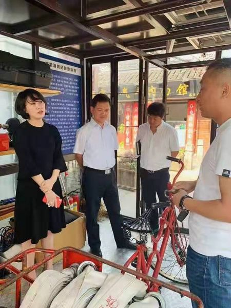 图说：李君遐（左一）检查老街微型消防站。