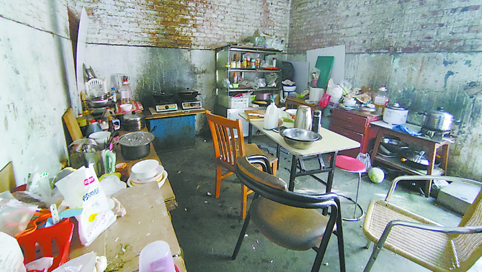 与库房一墙之隔的房间被当作厨房使用，屋内满是油污并存有液化气罐。