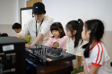 （少儿DJ课上Lin耐心辅导小学员）