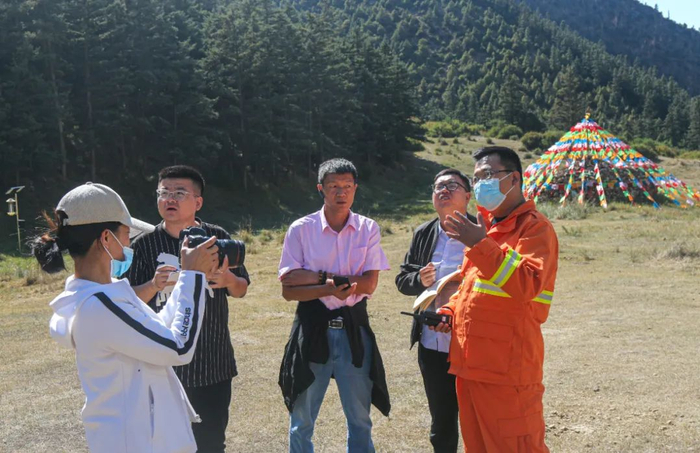 图为白瑞（右一）向记者介绍贺兰山国家级自然保护区采访生物多样性保护情况