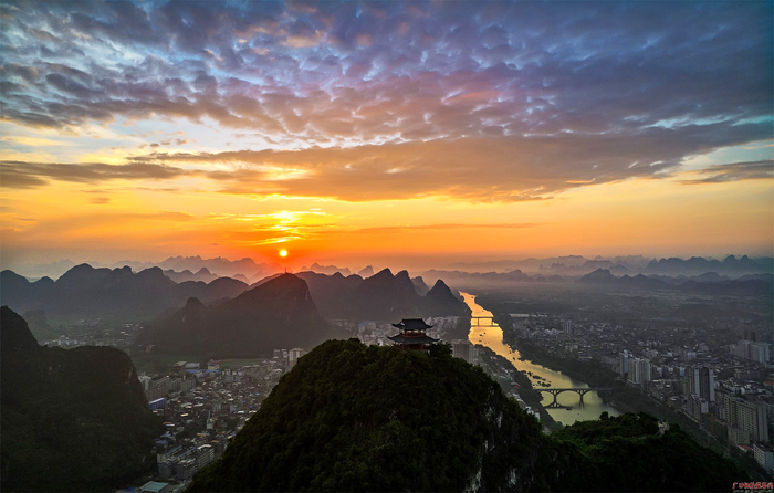金秋的朝阳温馨恰静，金秋的朝霞轻柔飘逸。图为宜州区金色九月的早晨，登高远眺，城市、山水、霞云、朝阳尽收眼底。（河池市宜州区纪委监委供图 范日昭/摄）