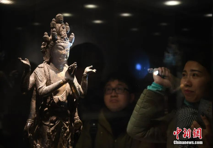 资料图：参观者被一尊观音立像吸引。中新社记者 王刚 摄
