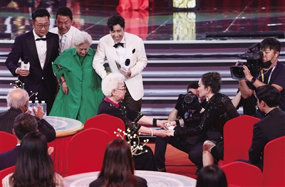 著名表演艺术家田华与本届电影节评委会主席巩俐亲切握手。
