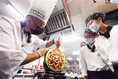 中餐烹饪专业主任牛京刚给学生讲解食品雕刻技术。图/记者 李木易