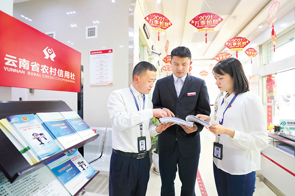 云南省曲靖市纪委监委紧盯以贷谋私、以权谋私等群众关注的重点领域开展违规借贷问题专项整治，严查金融风险背后的腐败问题。图为该市马龙区纪检监察干部在农信社查看贷款台账。