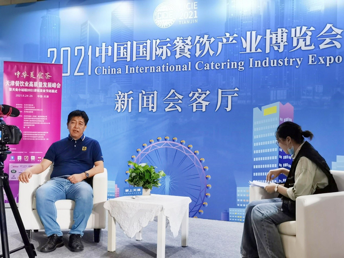天财商龙董事长丁晖（左一）接受媒体采访