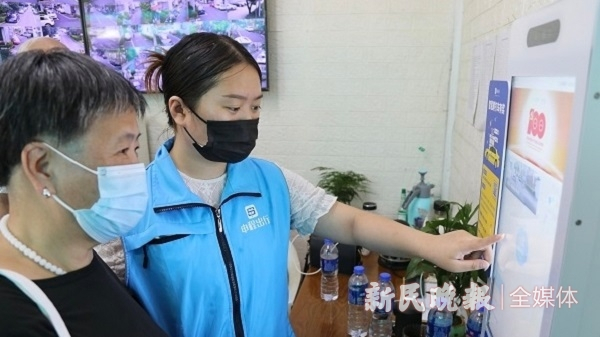 图说：志愿者帮助老人使用“一键叫车”智慧屏 新民晚报记者 陈梦泽 摄