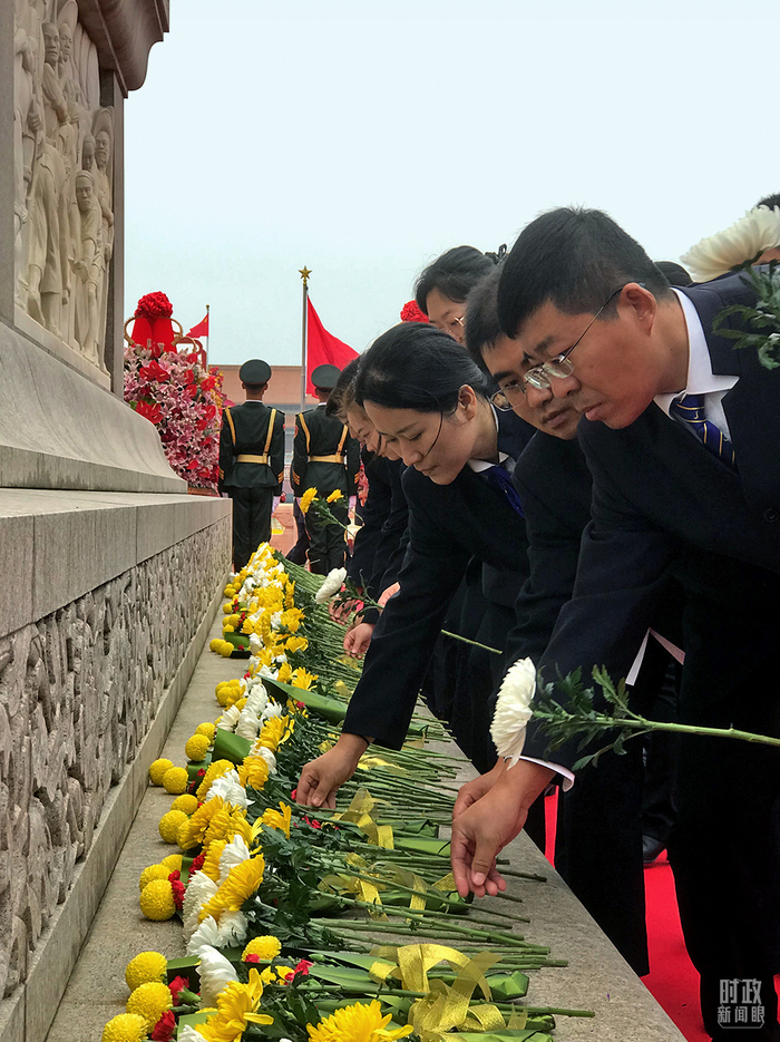 △各界群众代表在纪念碑前献上手中鲜花。（总台央视记者石伟明拍摄）