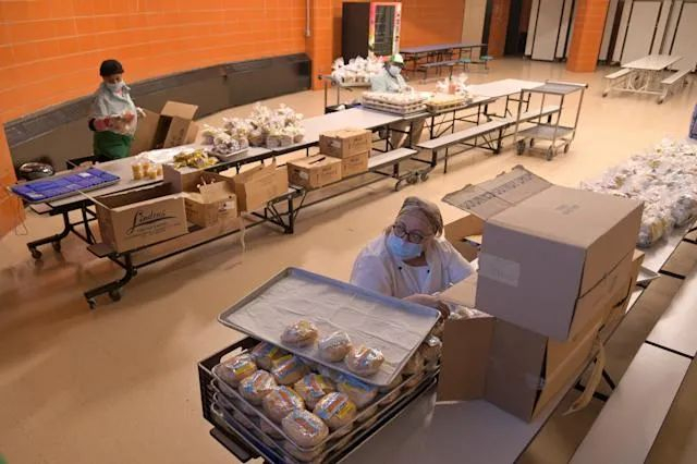 ▲学校餐饮部的工作人员在准备学生的餐点（美国《纽约时报》网站）