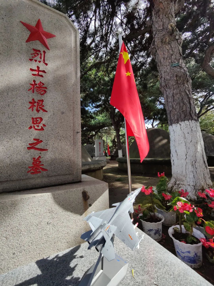 烈士杨根思墓碑前的“歼-15”战斗机模型。人民网 那其灼摄